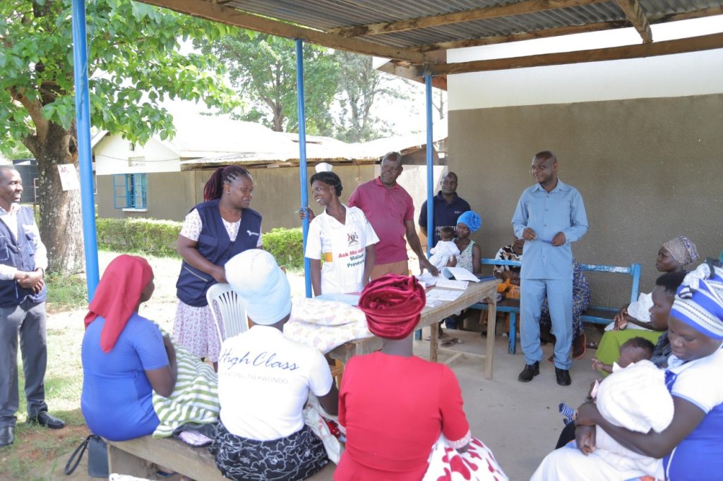 Field teams and Health Care Workers (HCWs) conducting orientation of VHTs on defaulter tracking during an immunization session.